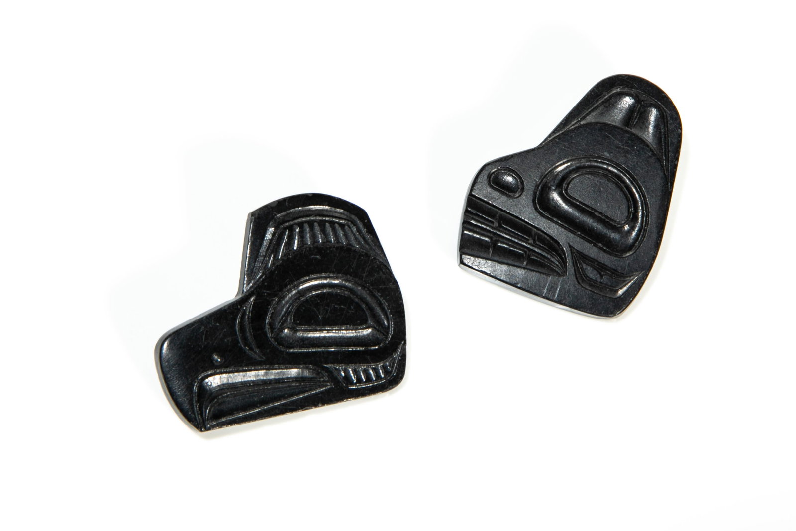 PAT McGUIRE, FIRST NATIONS, Pair of Brooches, 1967: PAT McGUIRE (1943-) HAIDA Pair of Brooches, 1967 each argillite and metal pins, 1.25 x 1 x 0.25 in (3.2 x 2.5 x 0.6 cm) each signed, inscribed, and dated "P. McGuire / Skidegate / 67". Provenance Priv