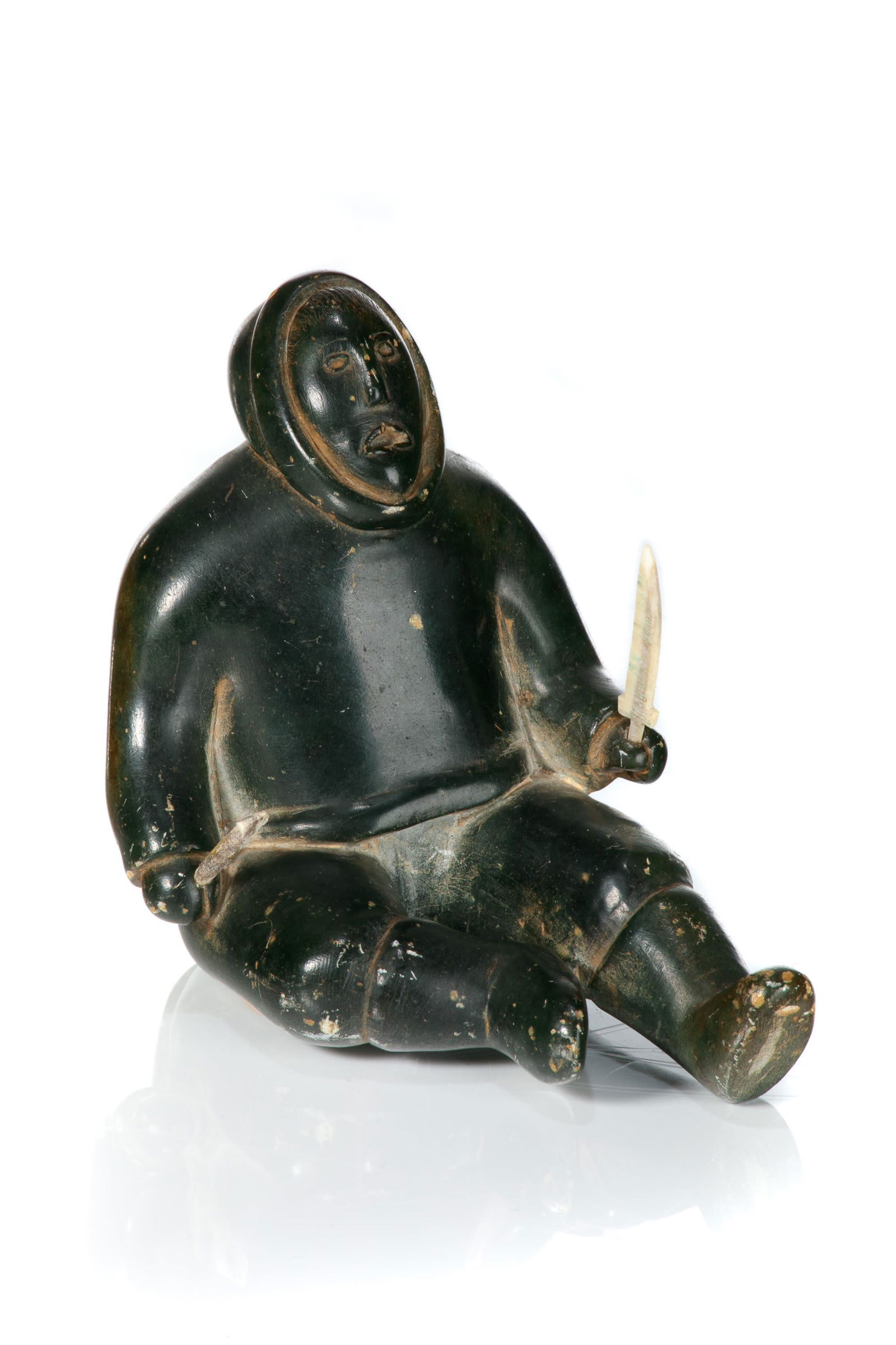 UNIDENTIFIED, INUIT, Seated Hunter with Arrow and Knife, late 1950s: UNIDENTIFIED ARTIST, INUKJUAK (PORT HARRISON), Seated Hunter with Arrow and Knife, late 1950s stone and antler, 4 x 3.5 x 5 in (10.2 x 8.9 x 12.7 cm) unsigned. Provenance Private Collection, New York.