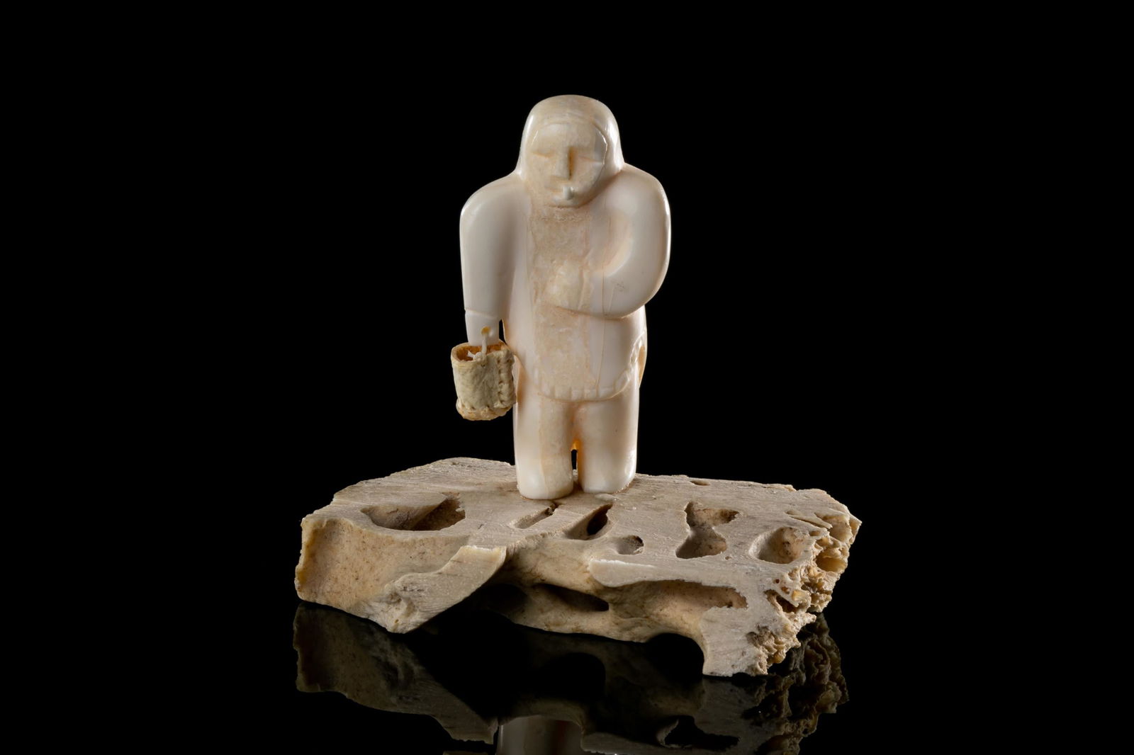 SABINA QUNQNIRQ ANAITTUQ, INUIT, Inuk with Pail and Pipe, c. 1980s: SABINA QUNQNIRQ ANAITTUQ (1941-) ARVILIQJUAQ (PELLY BAY) Inuk with Pail and Pipe, c. 1980s walrus tusk, string and whalebone, 2.75 x 3 x 2 in (7 x 7.6 x 5.1 cm) signed, 'ᓴᐱᓇ". Proven