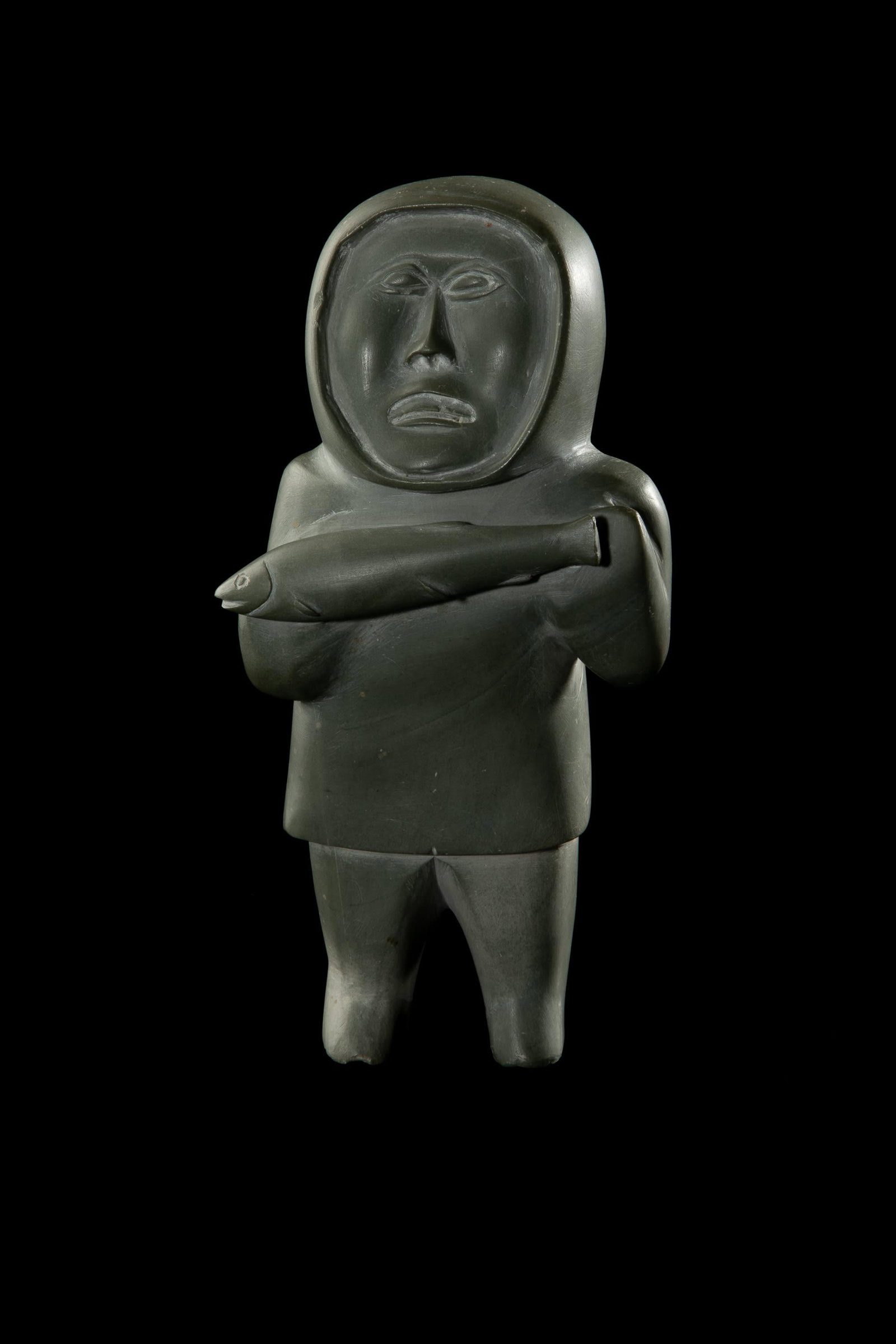 UNIDENTIFIED, INUIT, Standing Hunter with Caught Fish, 1960s: UNIDENTIFIED ARTIST, possibly SANIKILUAQ (BELCHER ISLAND) Standing Hunter with Caught Fish, 1960s stone, 8.75 x 4 x 3.25 in (22.2 x 10.2 x 8.3 cm) unsigned. Provenance Private Collection, New York.