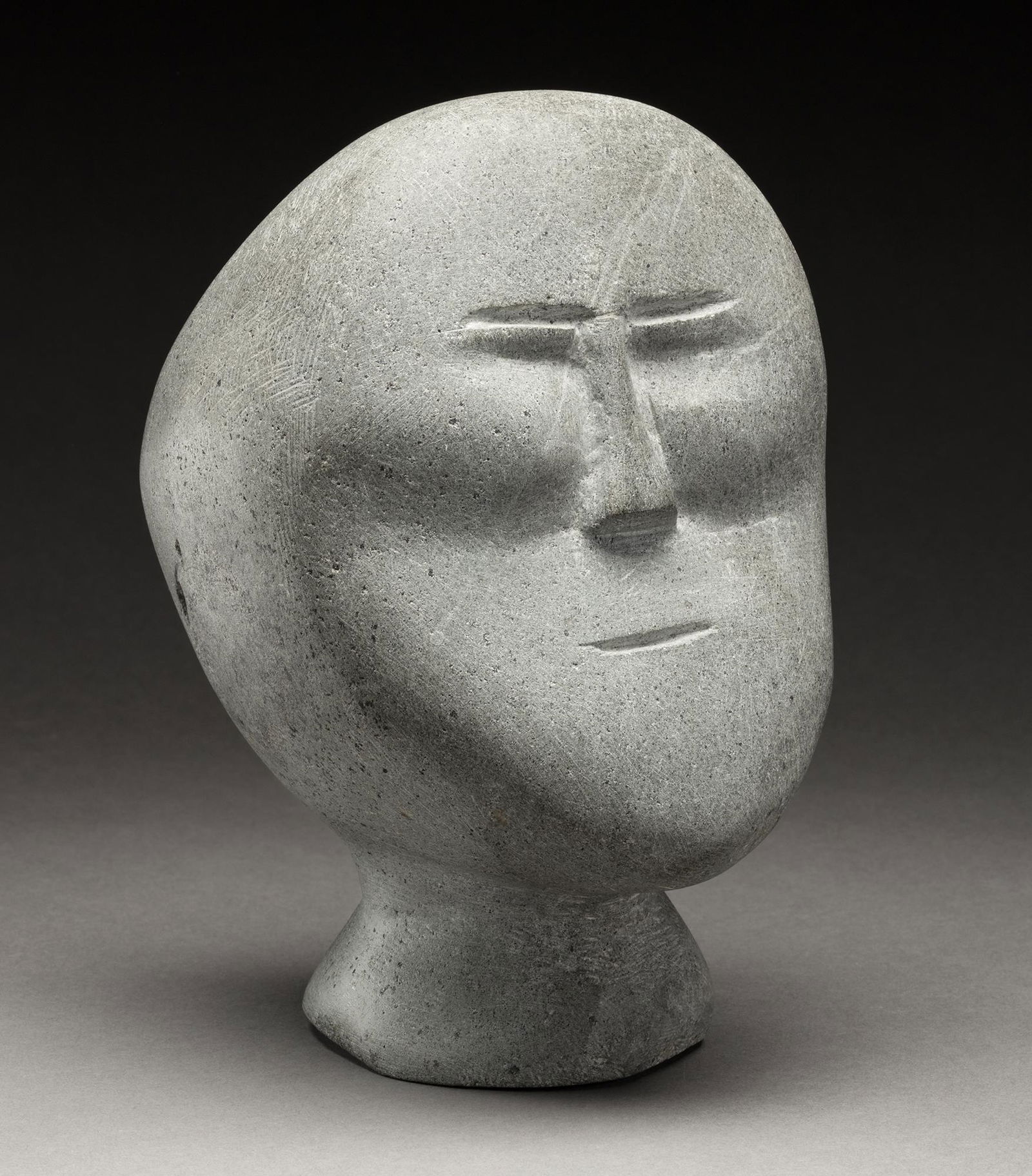 JOHN TIKTAK, INUIT, Head, c. 1964-65: JOHN TIKTAK, R.C.A. (1916-1981) KANGIQLINIQ (RANKIN INLET) Head, c. 1964-65 stone, 8 x 5 x 5.75 in (20.3 x 12.7 x 14.6 cm) unsigned. Provenance Marion Scott Gallery, Vancouver, BC; Acquired from the a