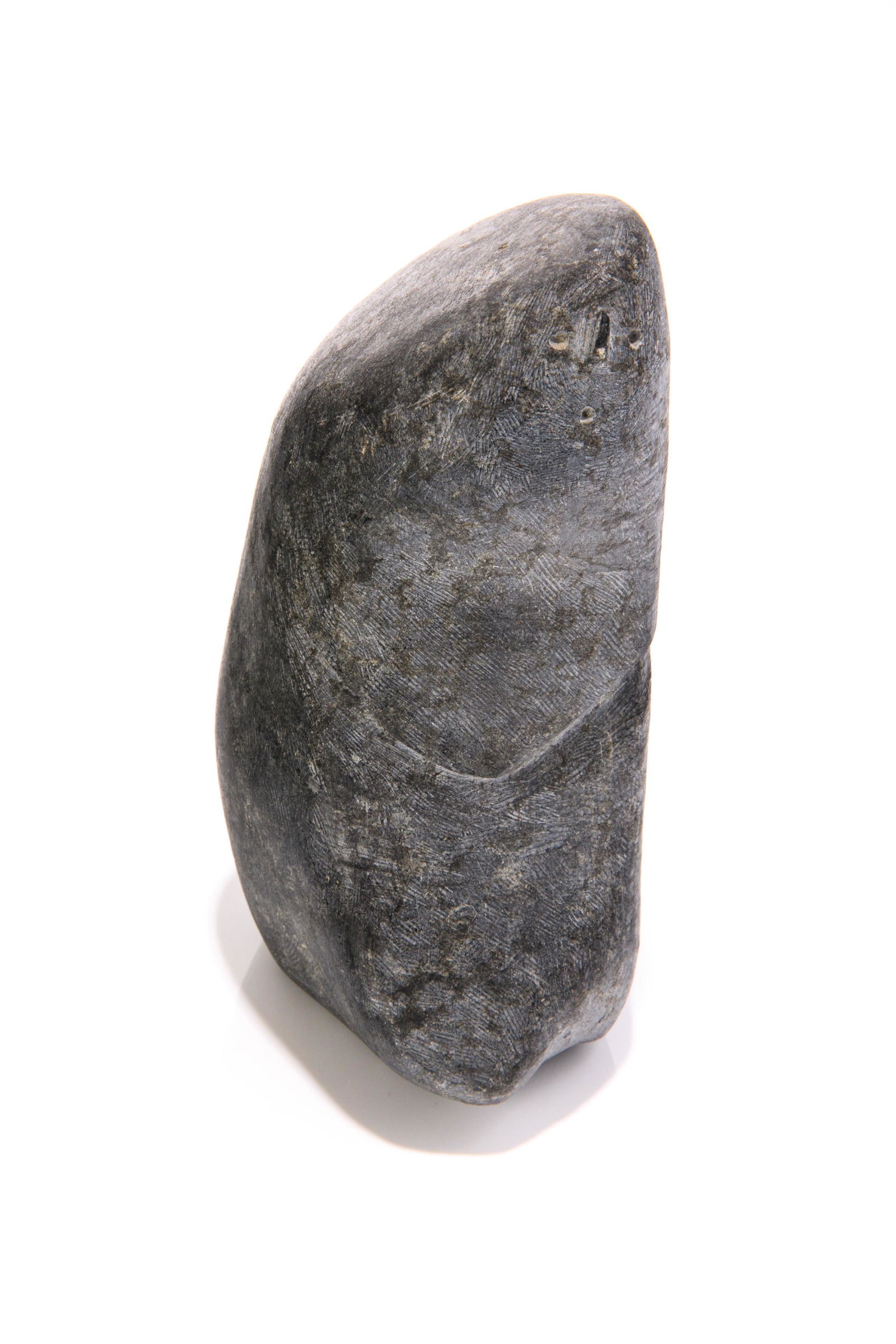 JOHN PANGNARK, INUIT, Figure with Clasped Hands, c. 1977-75: JOHN PANGNARK (1920-1980) ARVIAT (ESKIMO POINT) Figure with Clasped Hands, c. 1977-75 stone, 6 x 3 x 3.25 in (15.2 x 7.6 x 8.3 cm) signed, "ᐸᓂᔭ". Provenance INUK #1 Eskimo Art, San F