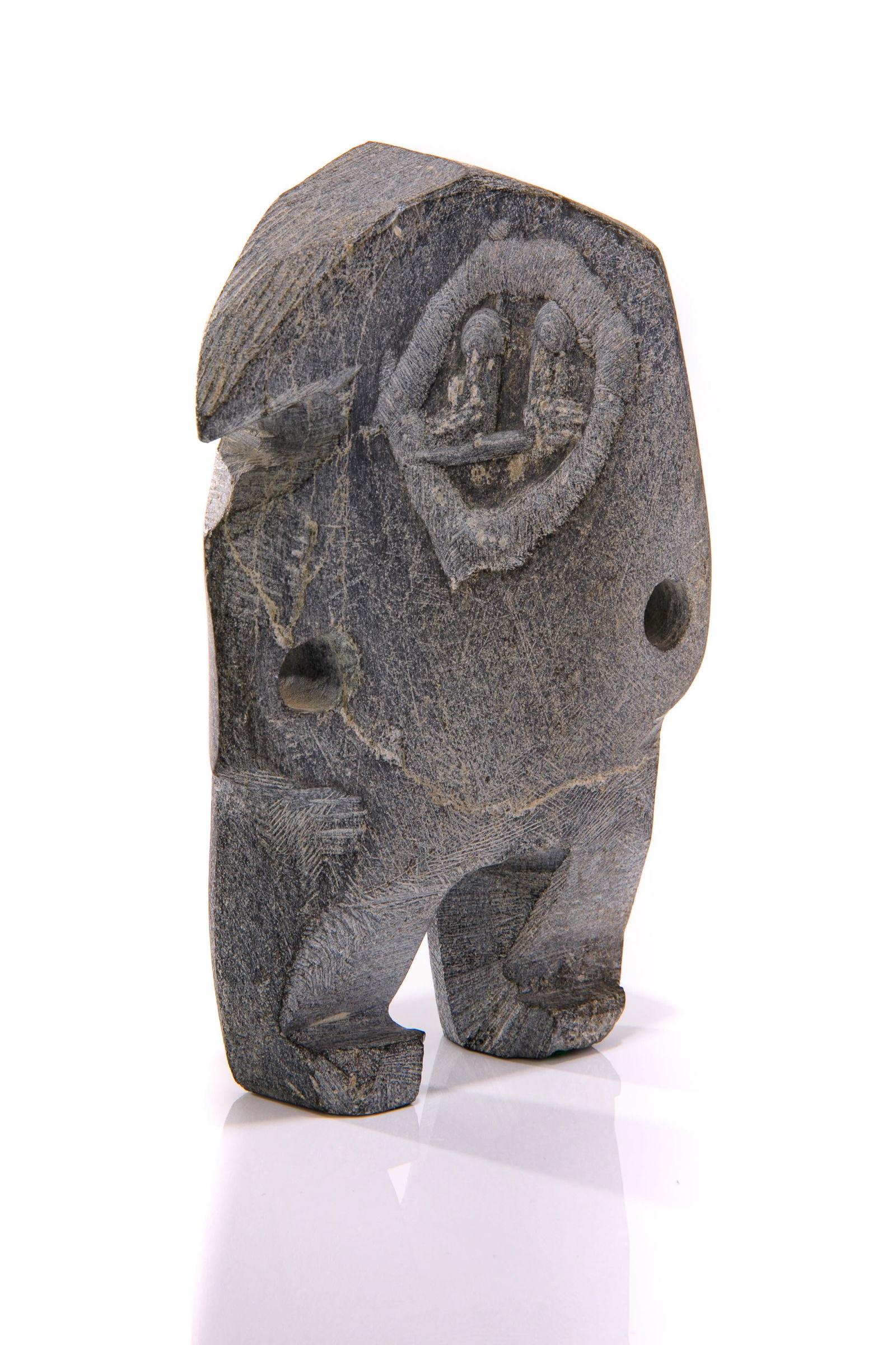 JOHN KAVIK, INUIT, Standing Inuk with Arms Akimbo, mid-late 1970s: JOHN KAVIK (1897-1993) KANGIQLINIQ (RANKIN INLET) Standing Inuk with Arms Akimbo, mid-late 1970s stone, 6 x 4.5 x 1.25 in (15.2 x 11.4 x 3.2 cm) signed, “ᑲᕕ”. Provenance Privat