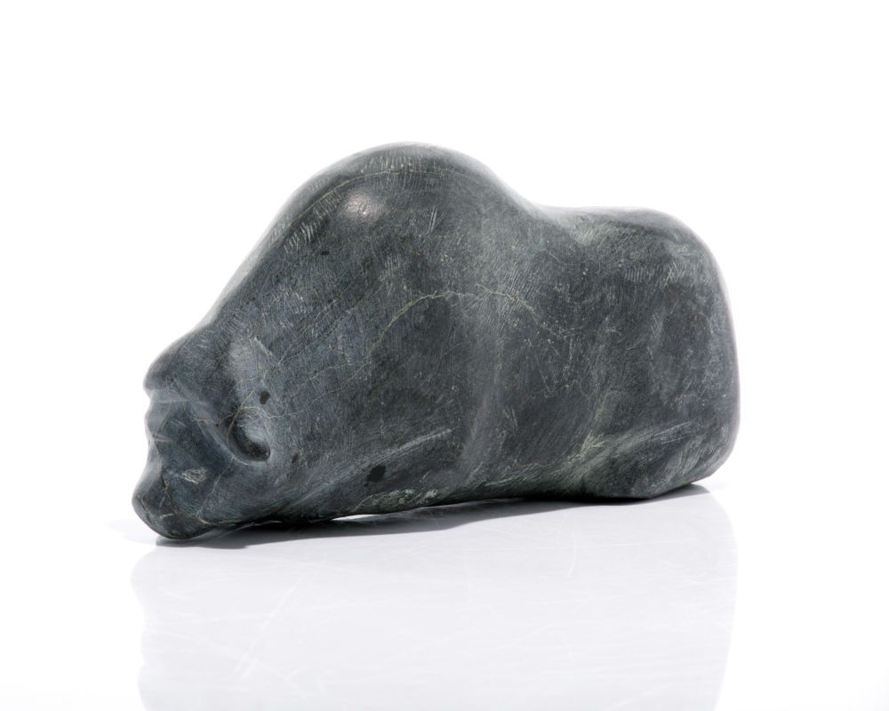 BARNABUS ARNASUNGAAQ, INUIT, Resting Muskox, 1980s: BARNABUS ARNASUNGAAQ (1924-2017) QAMANI'TUAQ (BAKER LAKE) Resting Muskox, 1980s stone, 3 x 6 x 2 in (7.6 x 15.2 x 5.1 cm) signed, "ᐊᓇᓱᒐ"; inscribed in an unknown hand, "1961 [?