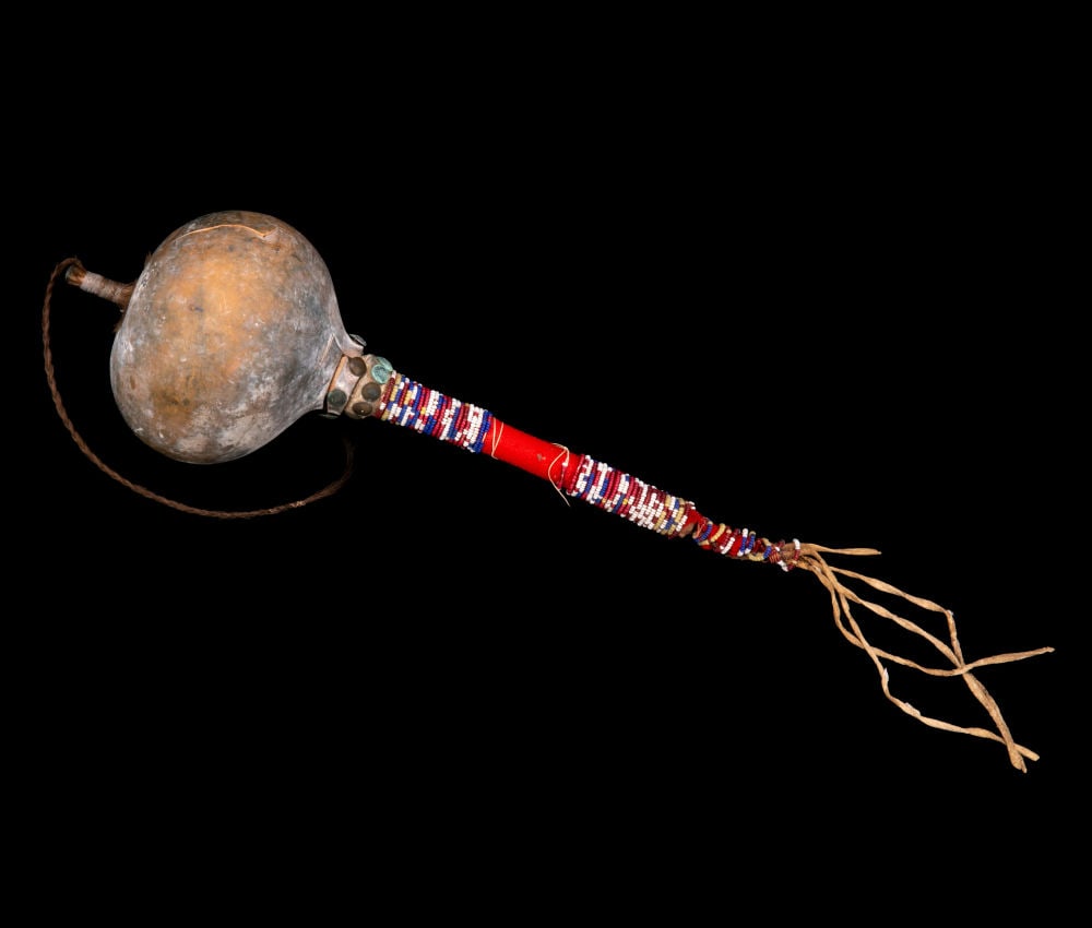 UNIDENTIFIED PLAINS ARTIST, POSSIBLY SIOUX, Model Gourd Rattle with Beaded Handle, early 20th centur: UNIDENTIFIED PLAINS ARTIST, POSSIBLY SIOUX Model Gourd Rattle with Beaded Handle, early 20th century gourd, wood, hide, glass beads, fabric, cotton string, brass tacks, pebbles, sinew, and hair, 11 x 