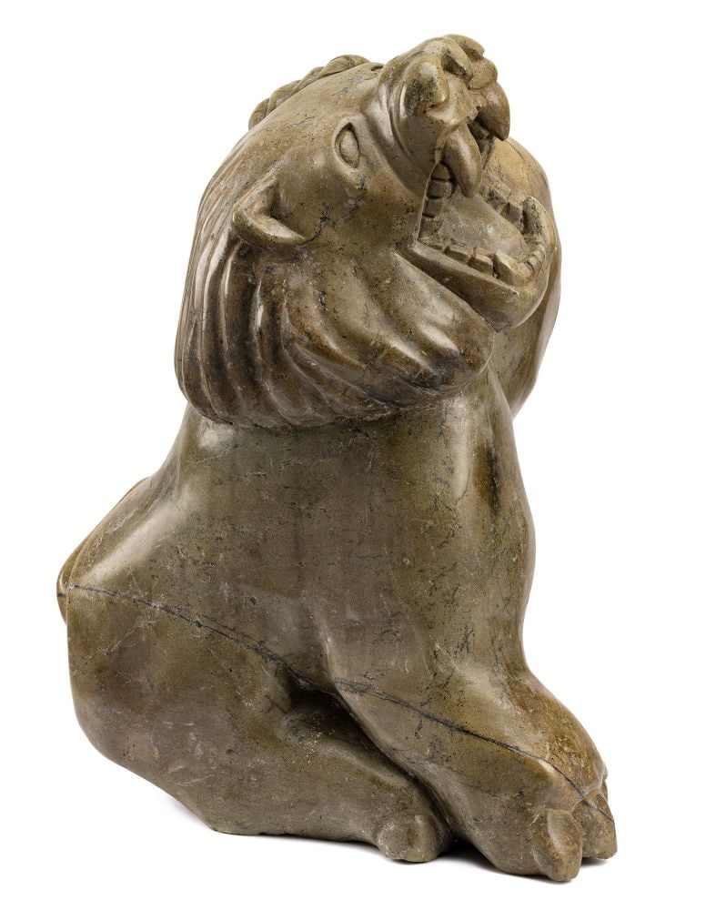 AQJANGAJUK SHAA, INUIT,, Lion, c. 1971: AQJANGAJUK SHAA, R.C.A. (1937-2019) KINNGAIT (CAPE DORSET) Lion, c. 1971 stone, 26 x 19.5 x 12.5 in (66 x 49.5 x 31.8 cm) signed, "ᐊᔭᒐᔪ". Provenance Private Collection, Toronto