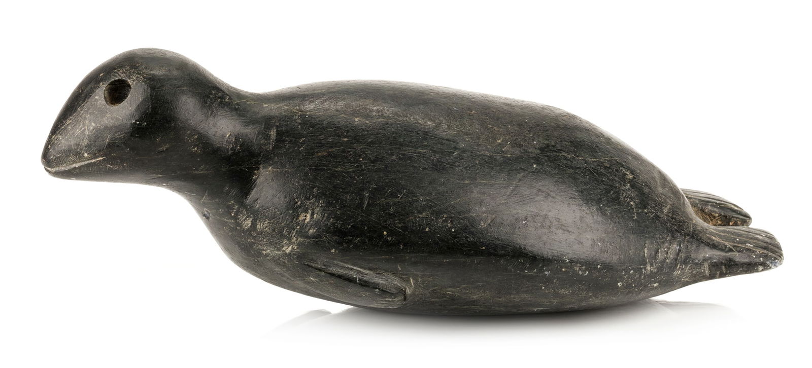 JOHN KAVIK, INUIT, Basking Seal, c. early 1960s: JOHN KAVIK (1897-1993) KANGIQLINIQ (RANKIN INLET) Basking Seal, c. early 1960s stone, 3.25 x 8.5 x 4.25 in (8.3 x 21.6 x 10.8 cm) unsigned. Provenance An Ottawa Collection. John Kavik is best known f