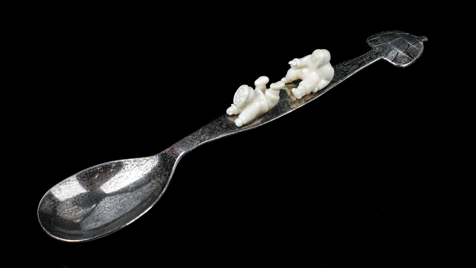 Poss: ELSIE KLENGENBERG, INUIT, Pewter Spoon with Igloo Finial and Two Men, 1999: Possibly: ELSIE KLENGENBERG (1946-) ULUKHAKTOK (HOLMAN) Pewter Spoon with Igloo Finial and Two Men, 1999 pewter and antler, 1.25 x 8 x 1.75 in (3.2 x 20.3 x 4.4 cm) signed and dated, " ELSIE K. 1999".