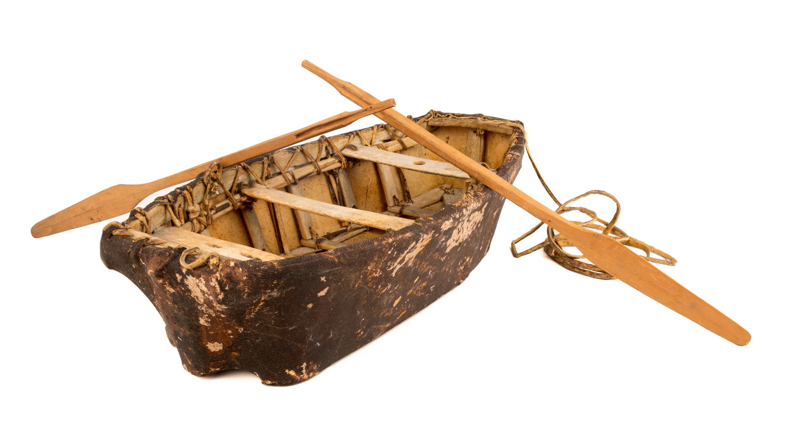 UNIDENTIFIED INUIT ARTIST, Model Umiak, c. 1960: UNIDENTIFIED ARTIST, KUUJJUAQ (FORT CHIMO) Model Umiak, c. 1960 sealskin, bone, and wood, vessel: 20 x 9 x 4 in (50.8 x 22.9 x 10.2 cm) / each paddle, length, 17 in (43.2 cm). unsigned; with affixed l