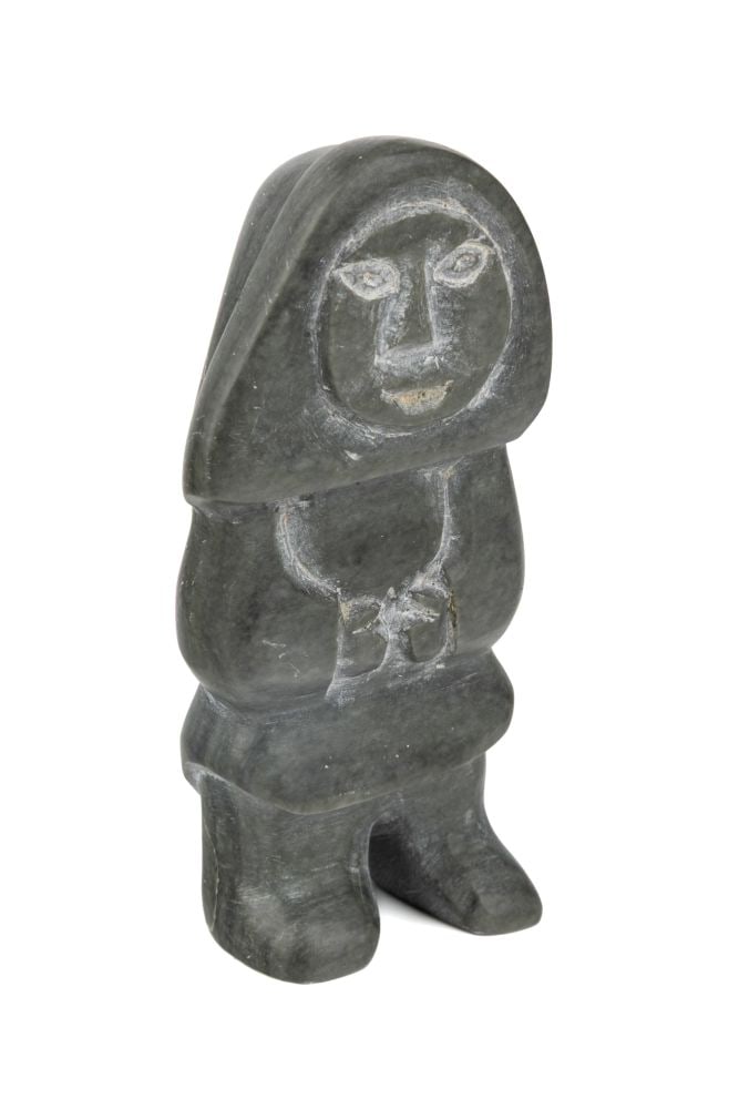 ANNIE NIVIAXIE, INUIT, Woman Standing, Hands Drawn In, 1975: ANNIE NIVIAXIE (1930-1989) KUUJJUARAPIK (GREAT WHALE RIVER) Woman Standing, Hands Drawn In, 1975 stone, 3.5 x 1.75 x 1 in (8.9 x 4.4 x 2.5 cm) signed and dated, "ᐊᓂ / ᓂᕕᐊ