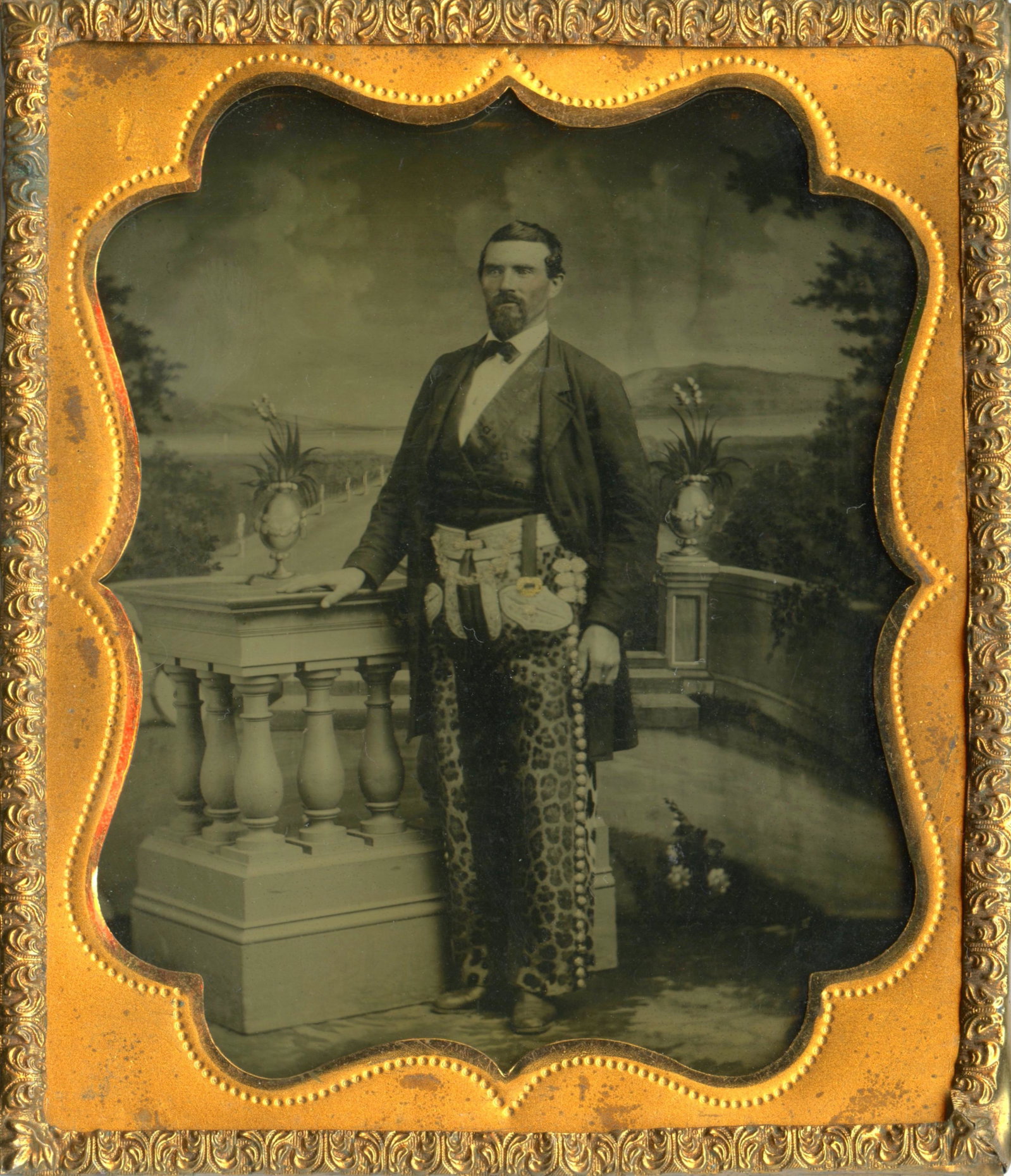 Remarkable Western Ambrotype- Man w/ Jaguar Chaps: Remarkable sixth plate ambrotype of a man wearing jaguar skin chaps held by a tooled white buff leather belt rig. The buttons down the side of his chaps and buckles on his belt rig are delicately acce