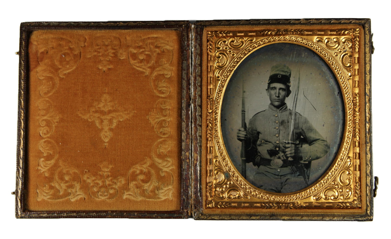[Civil War, Ambrotype] Triple-Armed Confederate : Triple-armed ambrotype photograph of an earnest young Confederate infantryman. Clad in a 9-button grey jacket and tall matching forage cap, this unknown rebel displays what appears to be his M1841 Mis