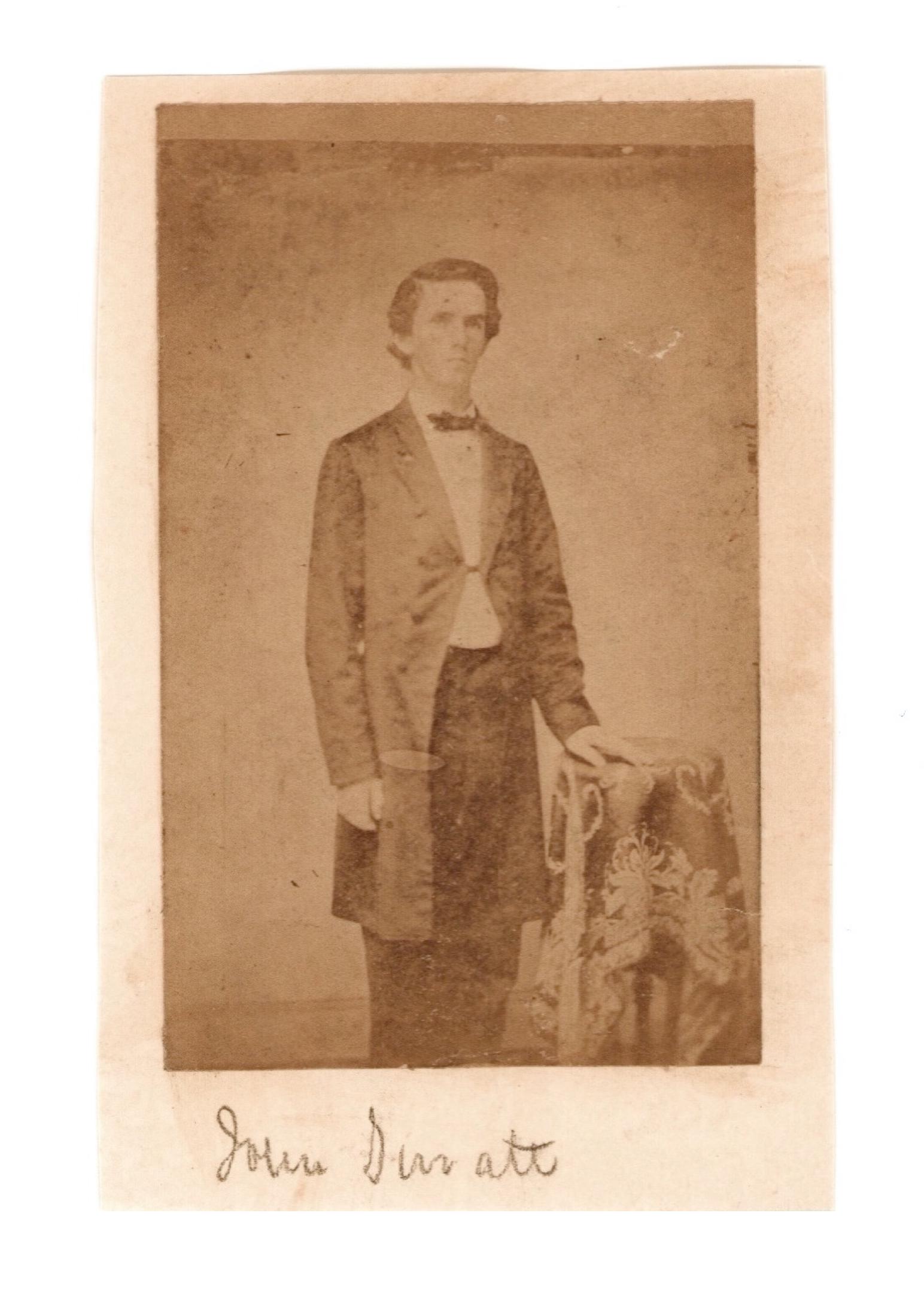 [Abraham Lincoln] Rare View of John Surratt : Exceedingly scarce carte-de-visite (CDV) portrait of John Surratt, a Lincoln Assassination conspirator. The image depicts a young and ordinary-looking Surratt in a full-length pose, clad in a simple d