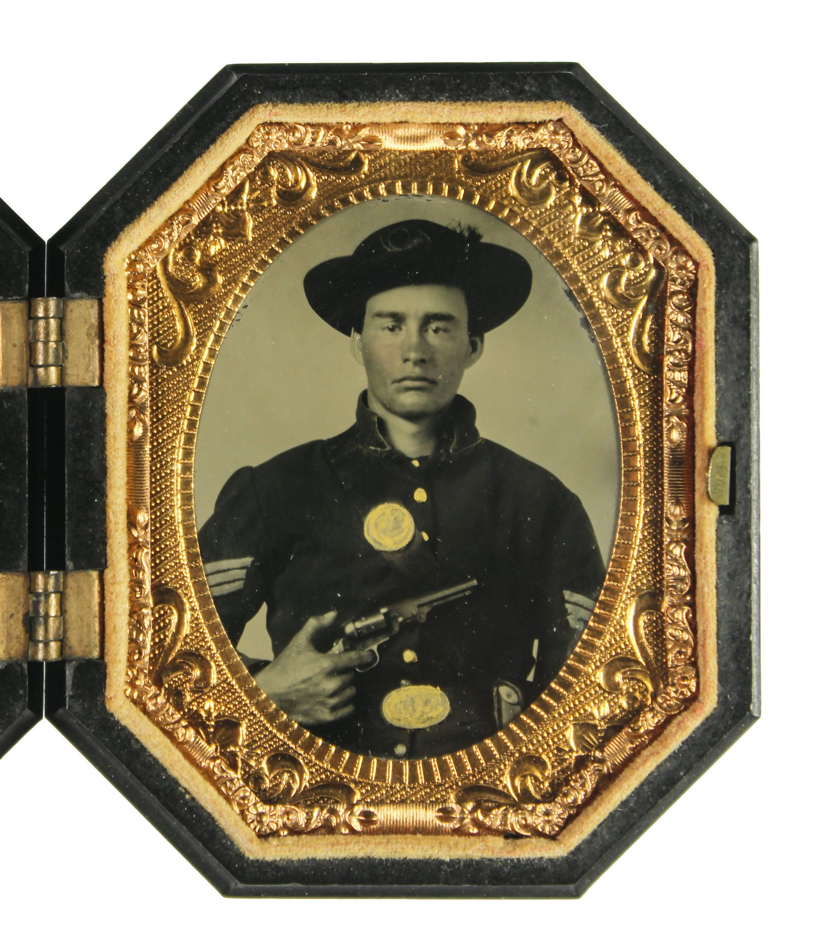 [CIVIL WAR] Armed Sergeant Octagonal Tintype: Hand-gilt studio sixth plate tintype. Full octagonal thermoplastic case with foliate motifs. A fine portrait of a fresh faced sergeant wearing a slouch hat. His uniform buttons and the plates on his w
