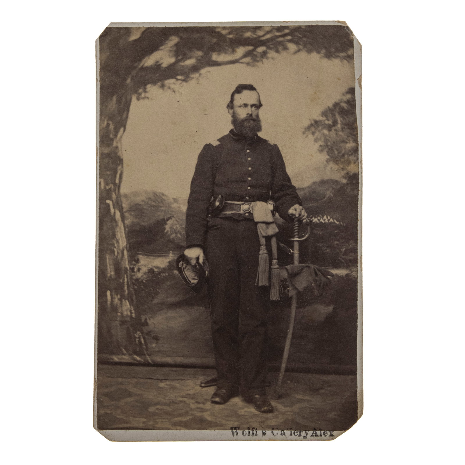 [GETTYSBURG] Gettysburg Cavalry Casualty: Outstanding Signed CDV of Capt. Robert Boyd, 1st New: An original albumen carte-de-visite full-length studio portrait of an officer standing before a painted landscape backdrop. He is impeccably outfitted in an officer's frock coat with line off