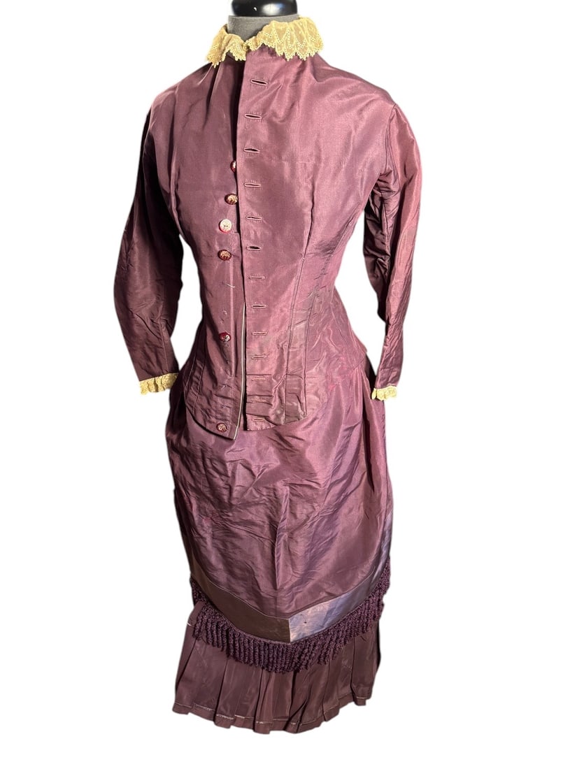 1870s Eggplant Taffeta Gown: Amazing example of high fashion in the mid 1870s. Has clearly been altered to fit a subsequent wearer but the alterations are exceptionally well executed. A mix of machine and hand sewing, hand-sewn b