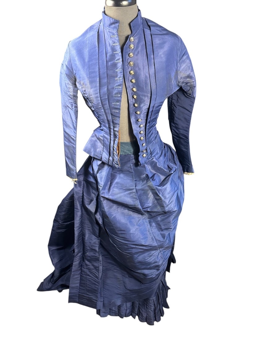 1860s Late Civil War Era Royal Blue Visiting/Day Dress with Dog Face Buttons: Exceptional construction in this two piece taffeta gown. The construction of the back reflects the later 1860s styling. Bodice has a combination of hand and machine sewing, hand-sewn button holes, cri