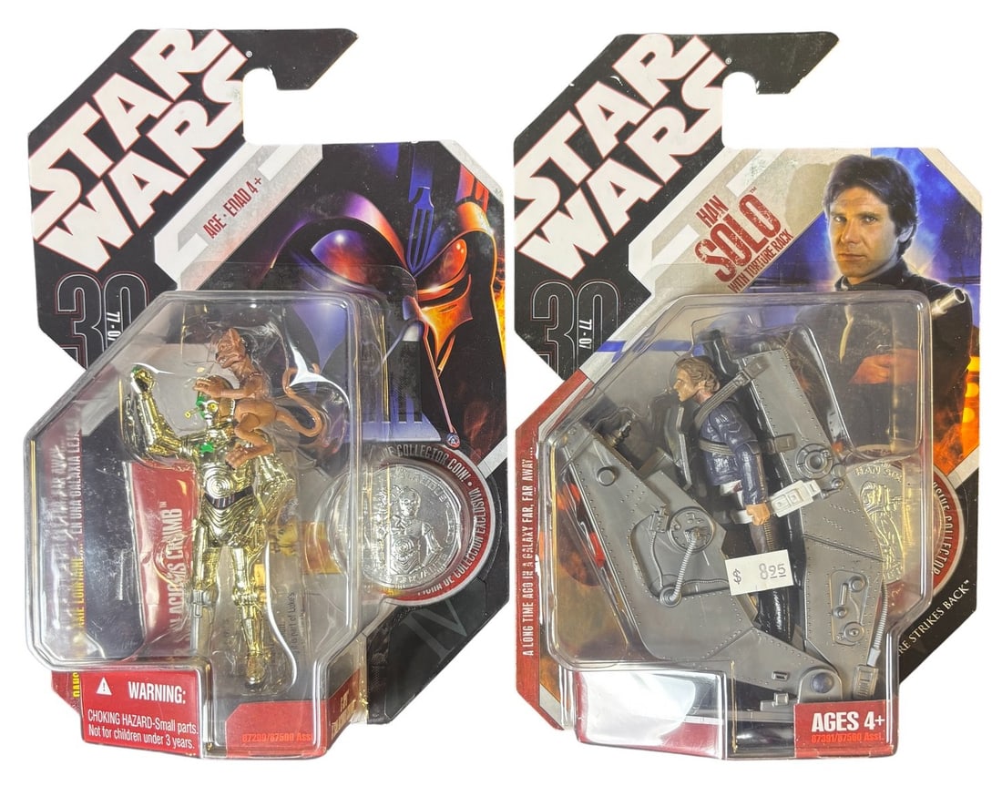 A Pair of Star Wars 30th Anniversary Collection Action Figures: Han Solo With Torture Rack and C-3po: A pair of Star Wars 30th Anniversary Collection action figures, still sealed in their original cardboard-backed blister packaging. The figure on the left depicts a gold-colored C-3PO with Salacious Cr