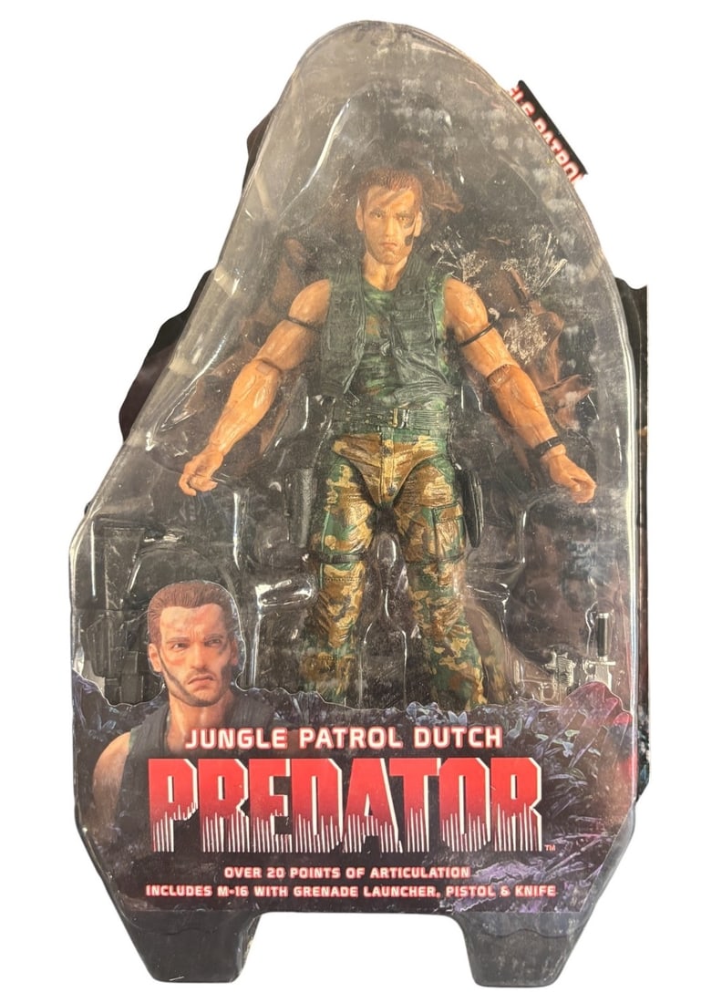 Neca Predator Series 8 Jungle Patrol Dutch Action Figure: A NECA Predator Series 8 Jungle Patrol Dutch action figure, presented new in its original, sealed blister card packaging. The modern plastic figure depicts a male character resembling Arnold Schwarzen