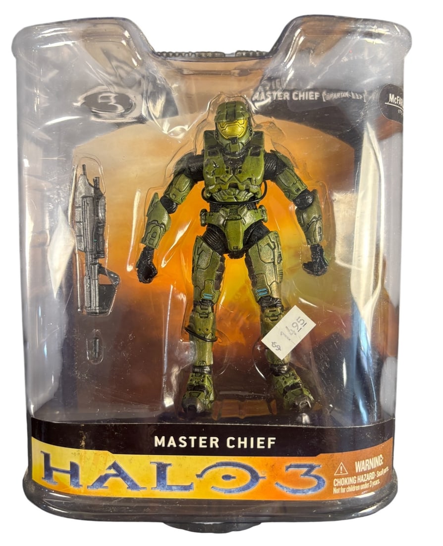 Mcfarlane Toys Halo 3 Series 1 Master Chief Action Figure: A McFarlane Toys Halo 3 Series 1 Master Chief Action Figure, depicting the character Spartan-117 in green armor. The figure is made of plastic and is sealed within its original clear plastic blister p