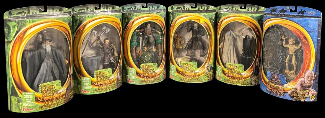 6 Toybiz Lord of the Rings Action Figures: A group of six ToyBiz Lord of the Rings action figures, each remaining sealed within its original cardboard-backed blister packaging featuring clear plastic domes. The lot includes figures of Gandalf,