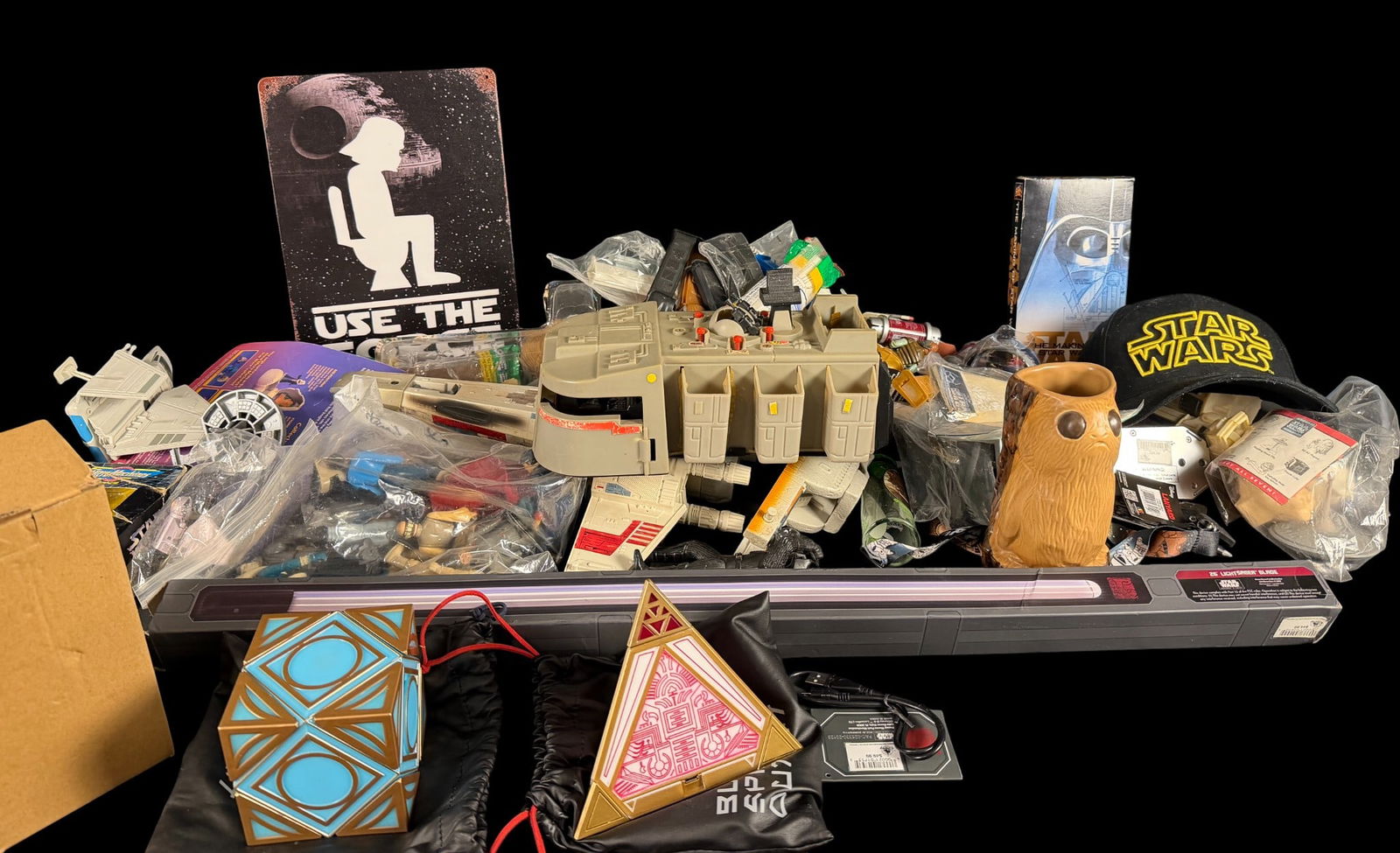 Star Wars Toys and Memorabilia including a Kenner Imperial Troop Transport: A collection of Star Wars toys and memorabilia. The group features a 1979 Kenner Imperial Troop Transport vehicle made of molded gray plastic. The assortment includes a Jedi holocron and a Sith holocr