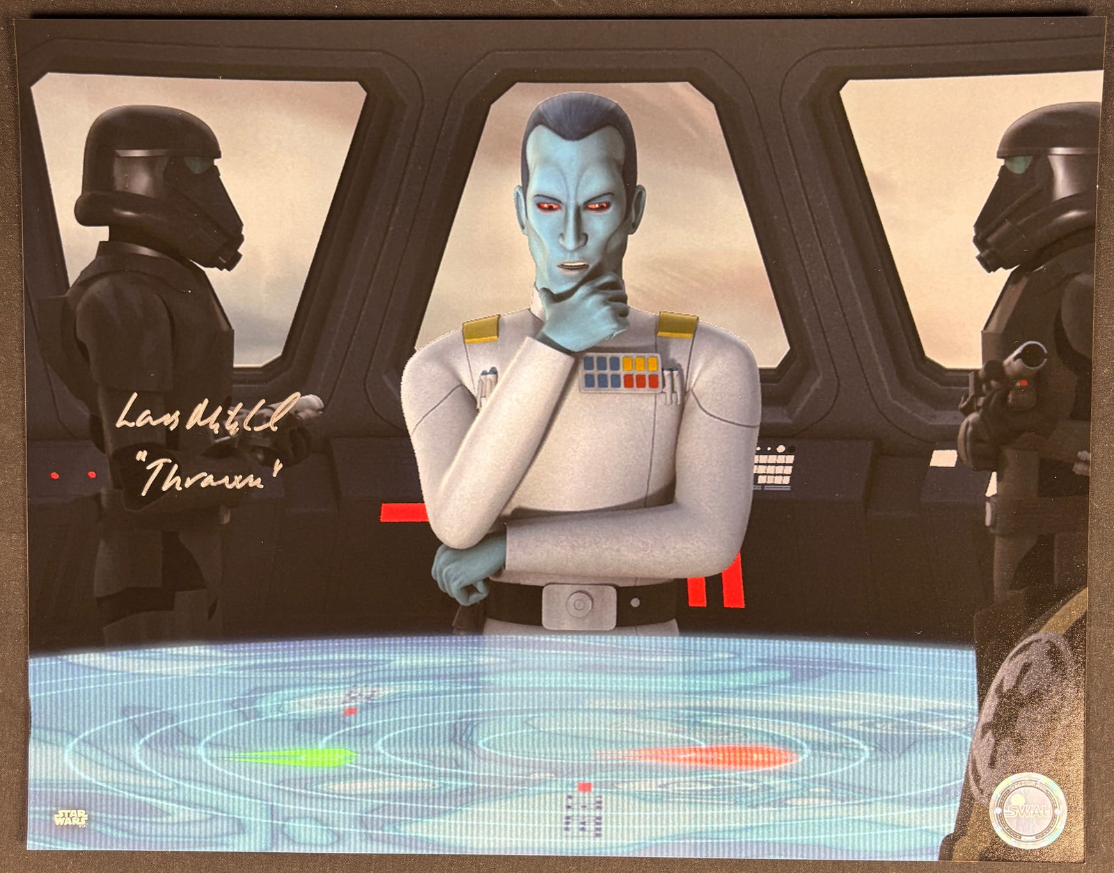 Lars Mikkelsen Signed Star Wars Rebels Grand Admiral Thrawn Animation Still Print: A color animation still print from the television series Star Wars Rebels, depicting the character Grand Admiral Thrawn at a tactical table flanked by Death Troopers. The item is hand-signed in metall