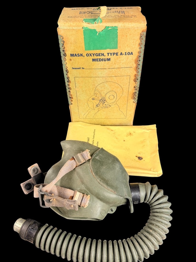 WWII AAF Type A-10A Oxygen Mask in Original Box: This lot consists of a World War II US Army Air Forces (USAAF) Type A-10A demand-type oxygen mask assembly, manufactured in May 1944. The mask is made of molded green rubber and is equipped with a cor