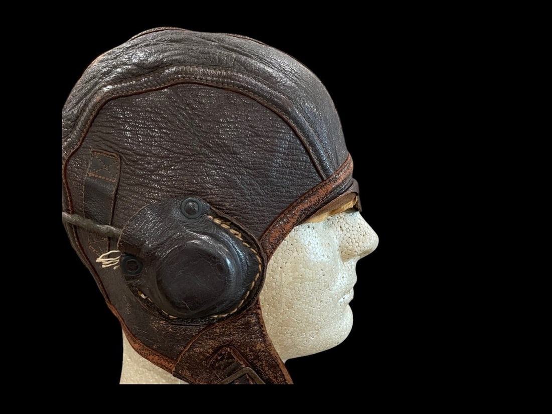 WWII USN Type NAF 1092 Flight Helmet with Avionics: This item is a World War II era United States Navy aviator flight helmet, model NAF 1092. The helmet is constructed from dark brown pebbled goatskin leather with a multi-panel design and reinforced do