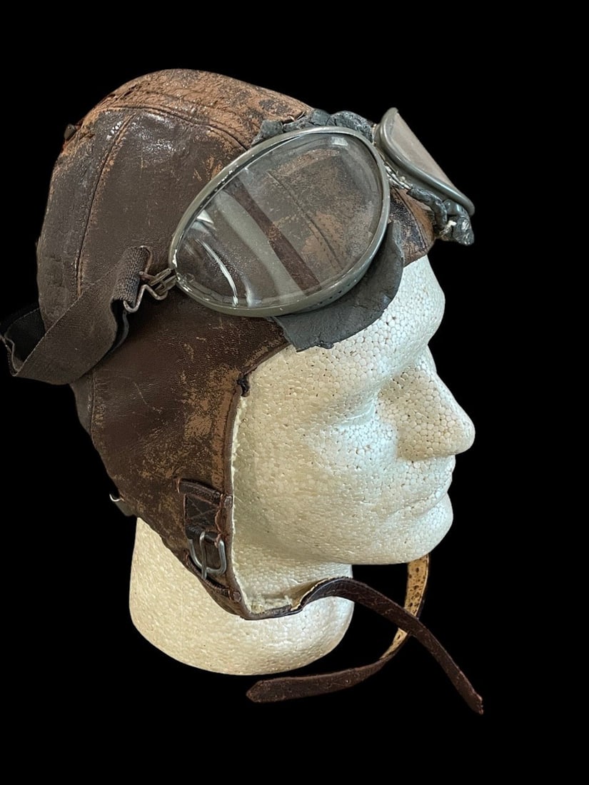 WWII German Luftwaffe Flight Helmet and Goggles: This lot consists of a WWII-era German Luftwaffe winter flight helmet, model LKp W 101, and a pair of flight goggles. The helmet is constructed of dark brown leather with a heavy interior lining of cr
