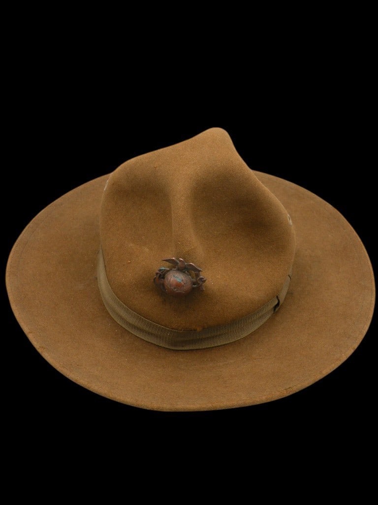 WW1 US Marine Corps enlisted campaign hat: This United States Marine Corps campaign hat, also known as a Montana peak hat, dates to the World War I era. The hat is constructed from olive drab wool felt and features the characteristic four symm
