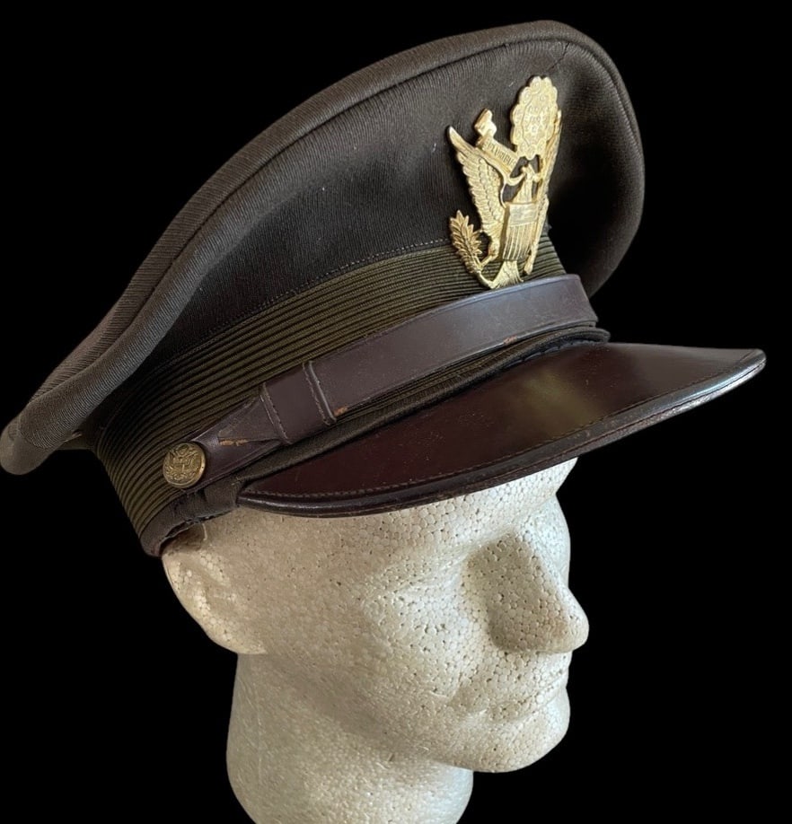 WWII US Army Officers Visor Cap Large: This World War II-era United States Army officer's service visor cap was manufactured by Stetson and is designated as the Luxury Model. The cap is constructed with a dark olive drab (OD-51) wool elast