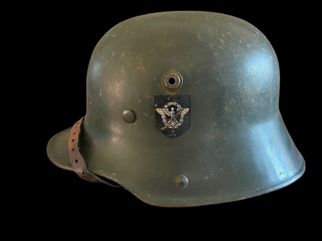 M16 SS Police Transitional helmet: This lot features an extremely rare artifact of the Nazi era: a WWI Model 1916 M16 Combat Helmet that was reissued for use by the SS-Polizei SS Police during the transitional period of the early