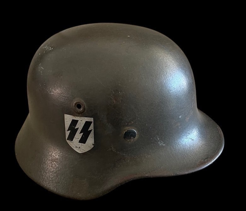 WWII German SS SD M40 Helmet: This lot presents a highly collectible and desirable example of a German Model 1940 (M40) Single Decal (SD) Waffen-SS Combat Helmet. The M40 model is identifiable by its rolled edge and the ventilatio