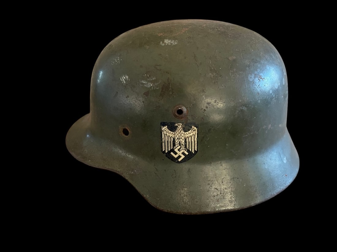 WWII German M35 Helmet Named: This lot features a highly sought-after artifact from the early years of World War II: a German Model 1935 M35 Double Decal Combat Helmet Shell, notable for its original decals, large size, and soldie