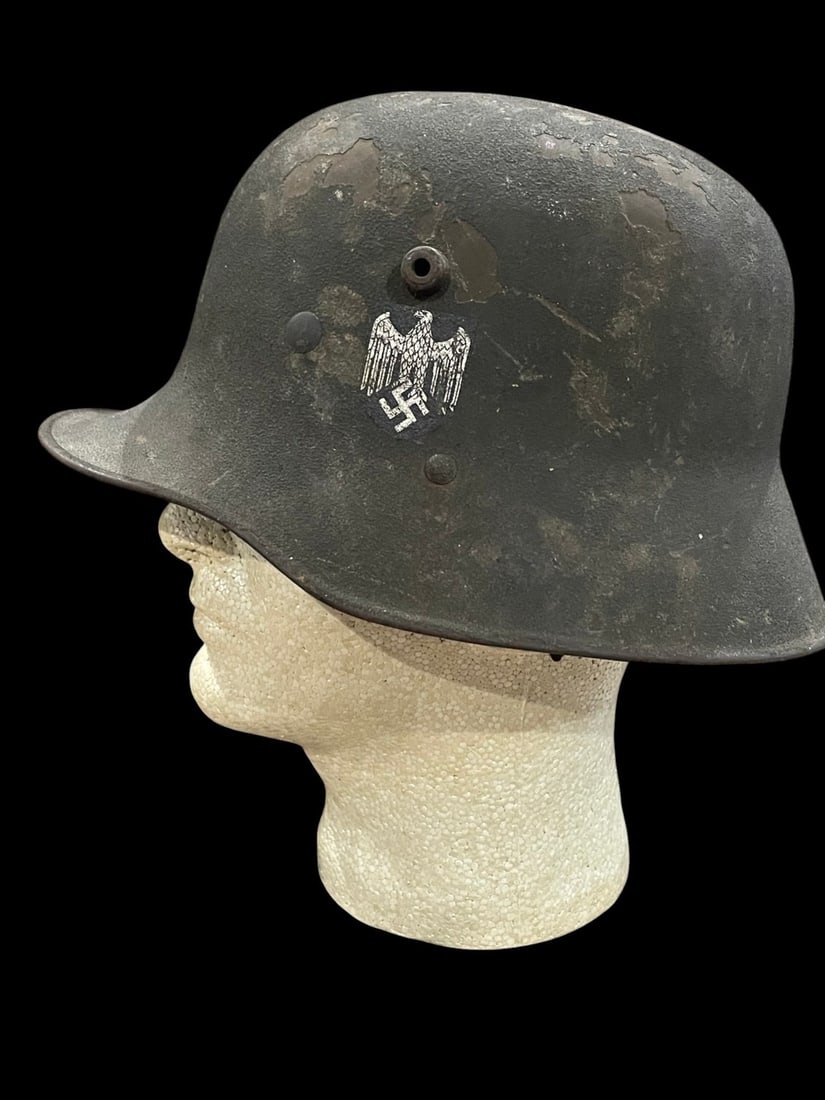 WW2 German M16 Transitional Single Decal Sand Camo Helmet: This is a German Army (Heer) transitional steel helmet, utilizing a World War I era M1916 pattern shell refurbished for service during the Third Reich period. The steel shell is characterized by a fla