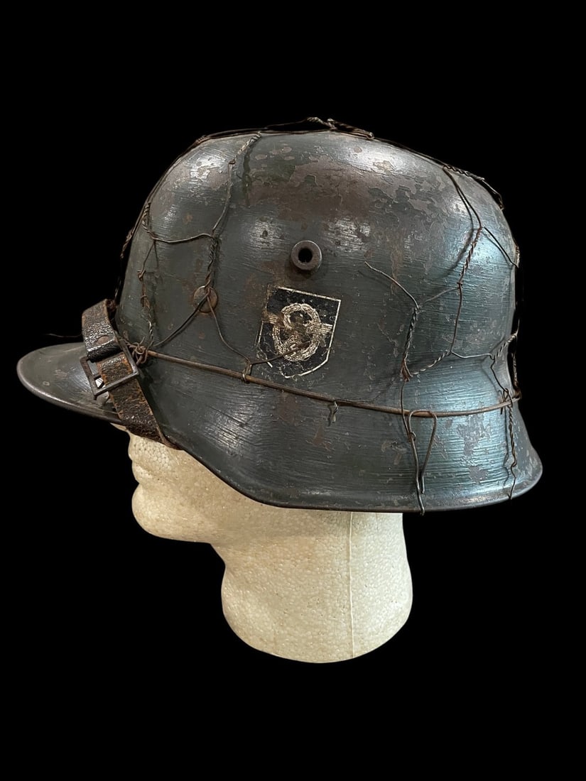WWII German M18 Transitional Police Helmet with Camo Wire: Extremely Rare German WWII M18 Transitional Double Decal Police Helmet with Wire Camouflage and ChinstrapThis lot presents an extremely rare and uniquely configured historical relic: a WWI Model 1918