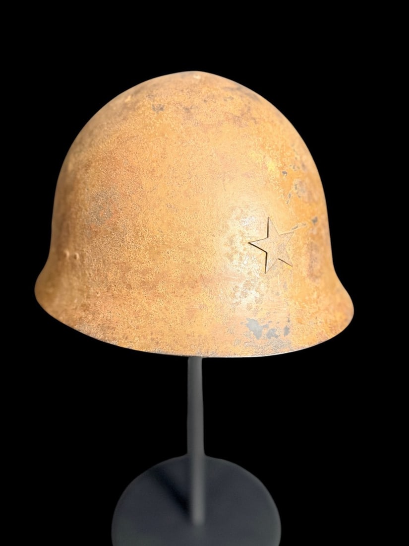 WWII Japanese Type 90 Combat Helmet: An Imperial Japanese Army Type 90 steel combat helmet, also known as a Tetsubo. The helmet features a characteristic sloping shell designed for shrapnel deflection. A fixed, raised metal five-pointed
