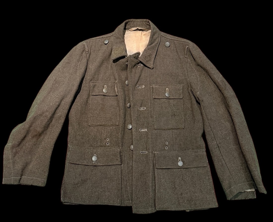 Original WWII German Heer Feldgrau Field Tunic M43 ? Combat Worn: original World War II German Army Heer field tunic in feldgrau wool, consistent with the M40/M43 pattern. The tunic features a six-button front closure, four pleated pockets with scalloped flaps, and