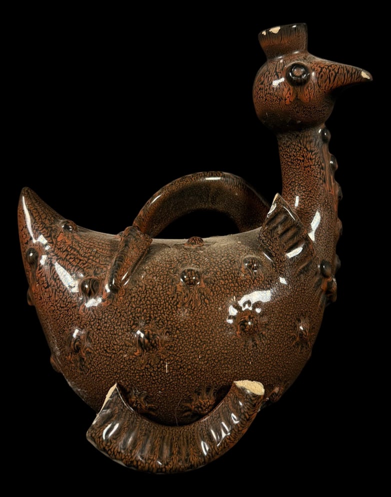 Peacock-Form Art Pottery Vase: Decorative art pottery vase modeled as a peacock with textured brown glaze, sculpted plumage, and an arched handle forming the tail.