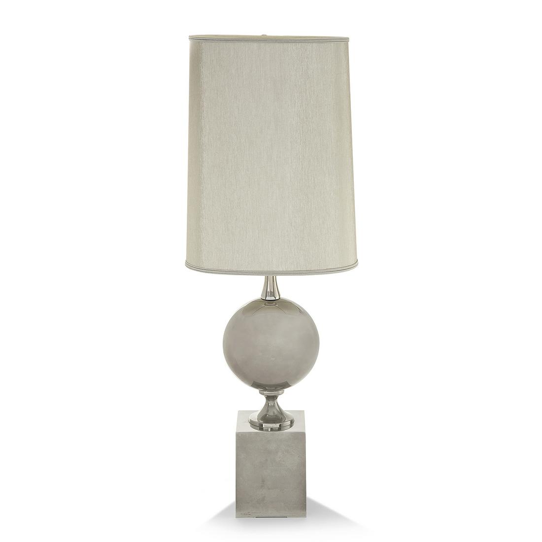 MAISON BARBIER (XXE SIÈCLE) Lampe à structure en acier: MAISON BARBIER (XXE SIÈCLE) Lampe à structure en acier poli, corps lenticulaire sur piédouche et haute base carrée, hampe supérieure diabolo. A polished steel lamp and base. H