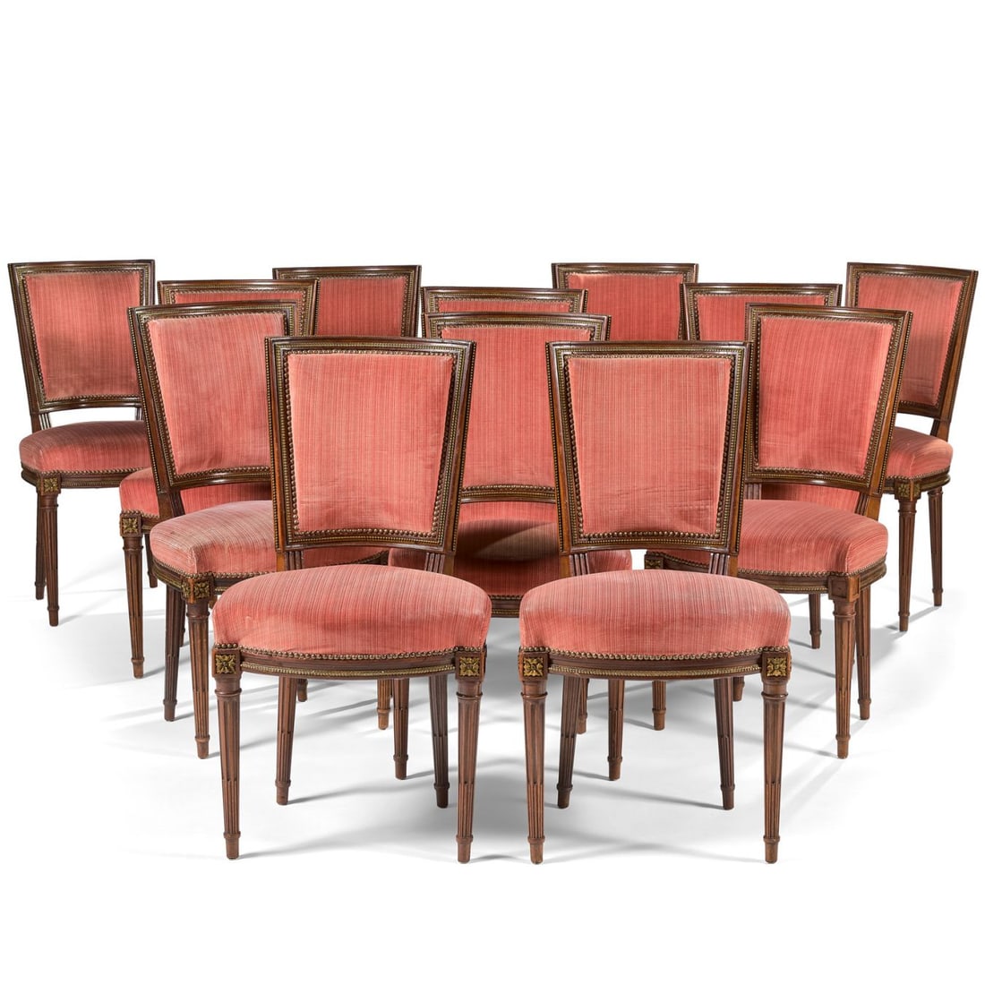 SUITE DE DOUZE CHAISES DE SALLE À MANGER, À DOSSIER EN CABRIOLET, STYLE LOUIS XVI, VERS 19: SUITE DE DOUZE CHAISES DE SALLE À MANGER, À DOSSIER EN CABRIOLET, STYLE LOUIS XVI, VERS 1900 en acajou mouluré et sculpté de cannelures et cannelures rudentées. Elles sont ornées de frises de ra