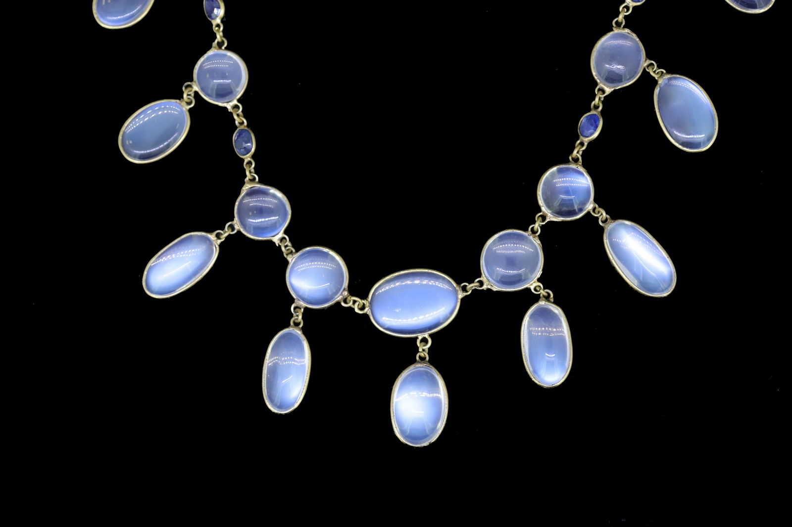 MOONSTONE AND SAPPHIRE NECKLACE: MOONSTONE AND SAPPHIRE NECKLACE, set with cabochon cut moonstones with 4 blue sapphire accents. L. 49 cm. 11.1 grams.