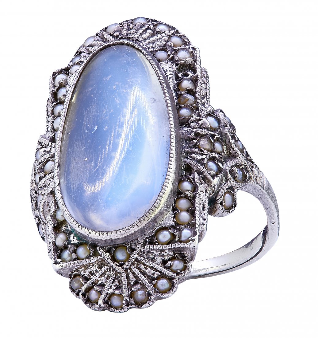 MOONSTONE AND PEARL DRESS RING: MOONSTONE AND PEARL DRESS RING, set to the center with a cabochon cut moonstone, flanked with pearls to the sides and shoulders. Size K. 7 grams.
