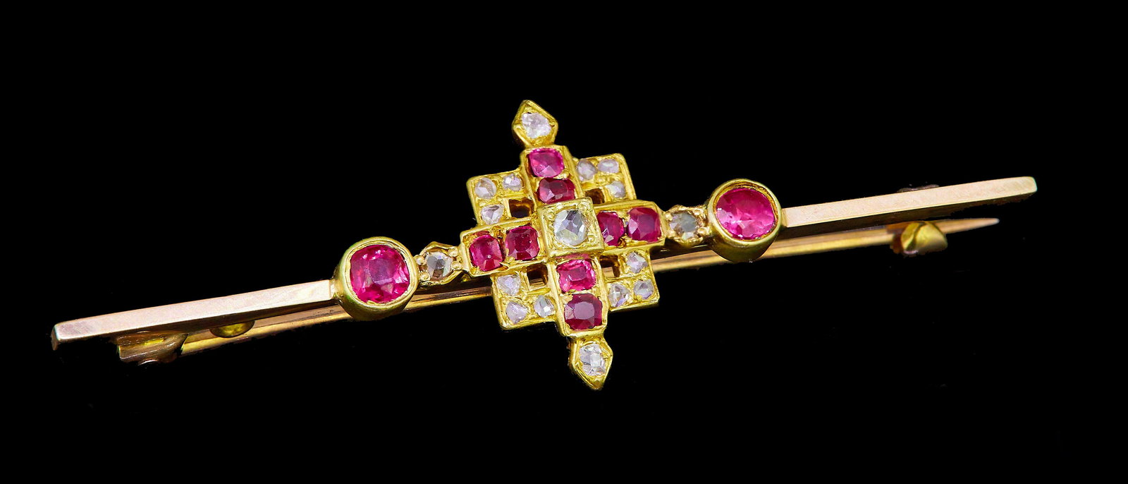 RUBY AND DIAMOND BROOCH: RUBY AND DIAMOND BROOCH, the center part of square design, set with diamonds and rubies, flanked by a ruby on each side. L. 5 cm. 5.9 grams.