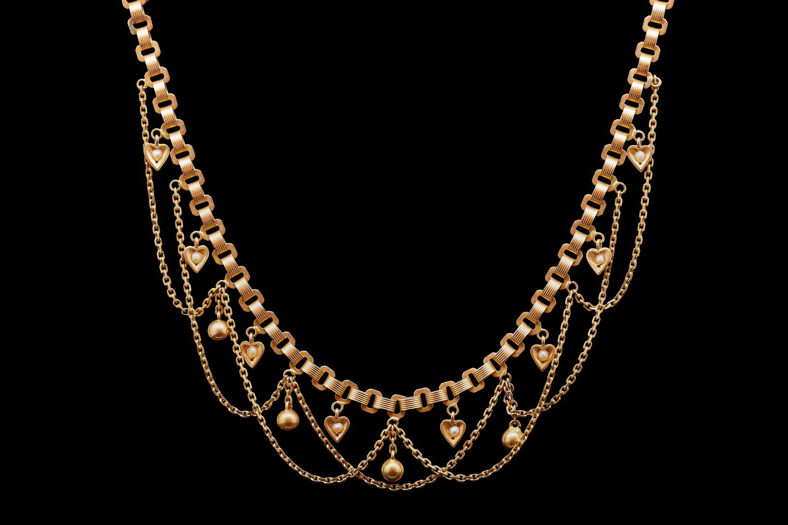 ANTIQUE VICTORIAN PEARL DROP NECKLACE: ANTIQUE VICTORIAN PEARL DROP NECKLACE, the link neklace with garland drop to the bottom section, alternated with pearl set heart drops, and ball drops. L. 38 cm. 11.7 grams.