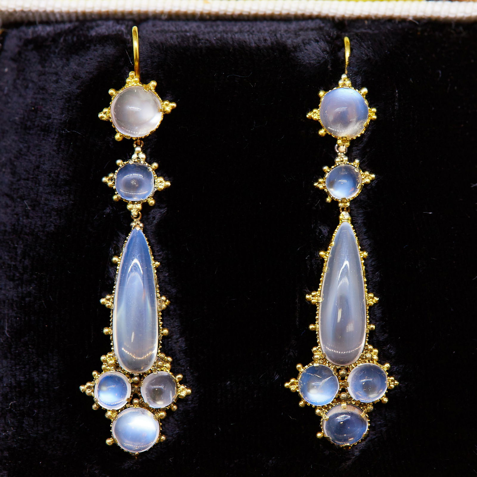 PAIR OF ANTIQUE MOONSTONE DROP EARRINGS: PAIR OF ANTIQUE MOONSTONE DROP EARRINGS, set with round cabochon cut moonstones and a largar pear shaped cabochon cut moonstone to the center. the surmount decorated with granulation. L. 5 cm. 4.8 gra