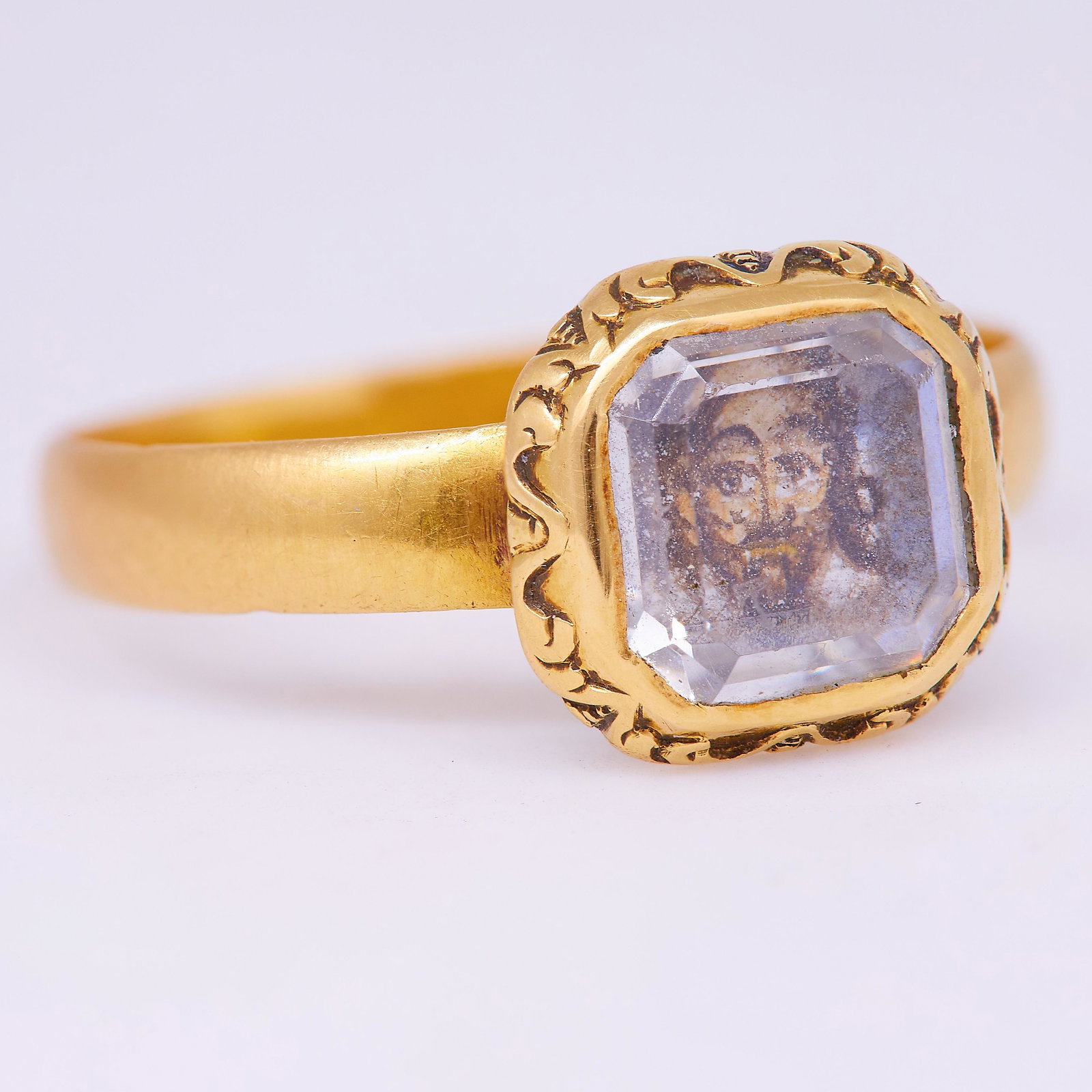 IMPORTANT STUART CRYSTAL PORTRAIT RING OF KING CHARLES: IMPORTANT STUART CRYSTAL PORTRAIT RING OF KING CHARLES THE 1ST, the center with a portrait of King Charles the 1st, underneath a stuart crystal. The border of the cullet with relief design, and the ba