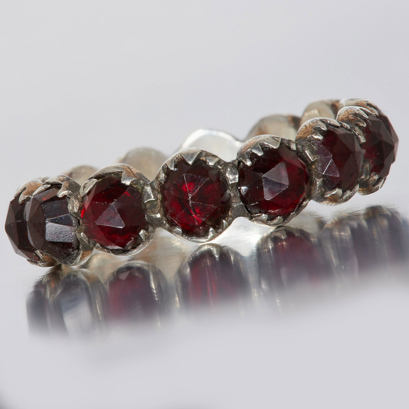 NO RESERVE, GARNET ETERNITY RING: NO RESERVE, GARNET ETERNITY RING. totaling 14 stones. size M. 2.1 grams.