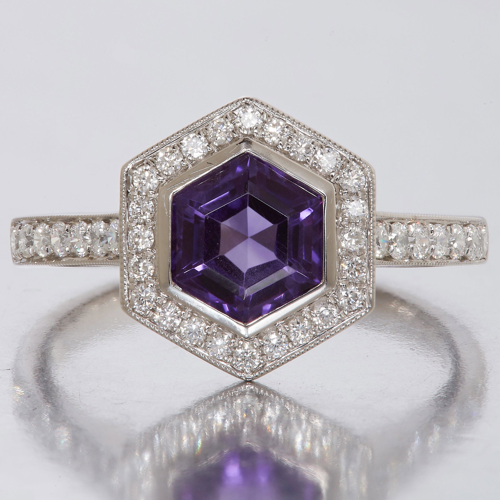 NO RESERVE, AMETHYST AND DIAMOND CLUSTER RING: NO RESERVE, AMETHYST AND DIAMOND CLUSTER RING, in 18 ct. gold. Set to the center with an hexagonal cut amethyst, flanked with diamonds and diamonds on the shoulders and part shank, totalling approx. 0
